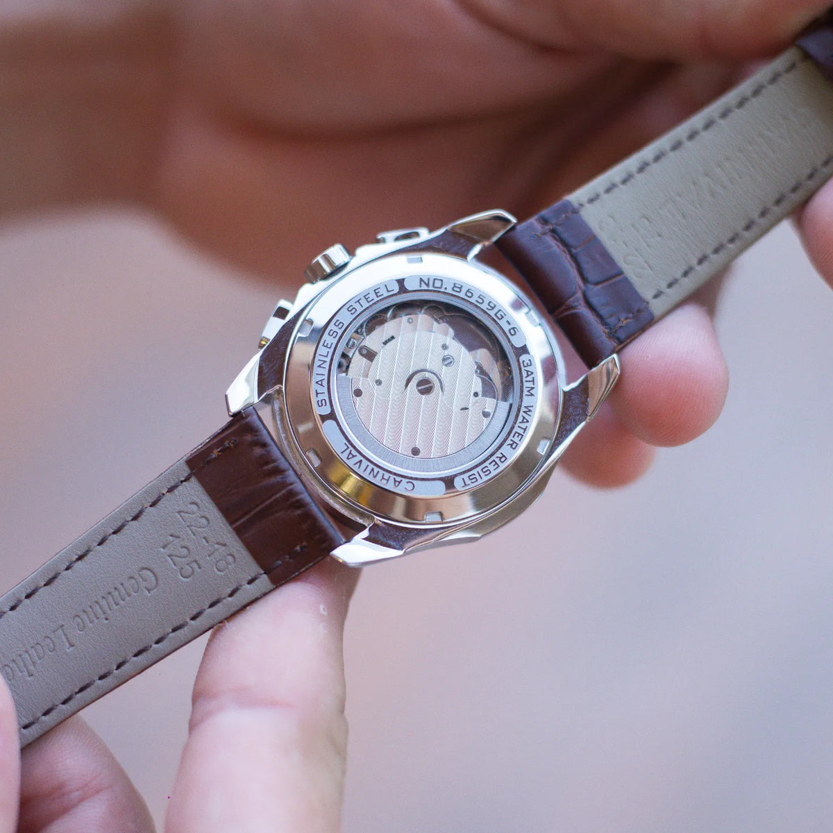 DALMONT Navigator watch held in hand, caseback and leather strap detail