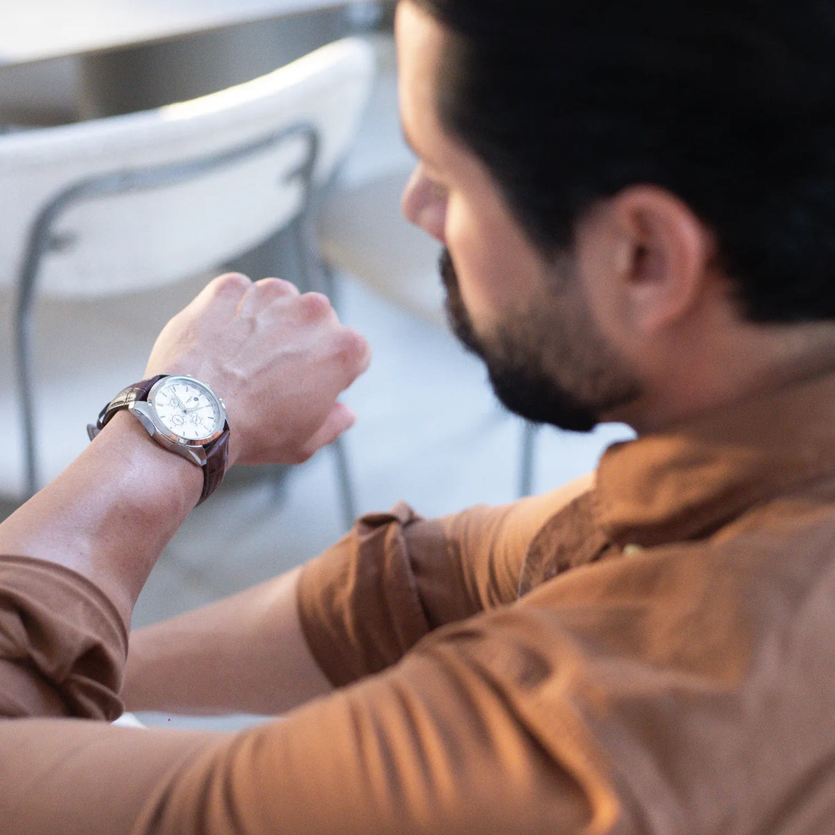 DALMONT Navigator watch on the wrist, checking the time at a table