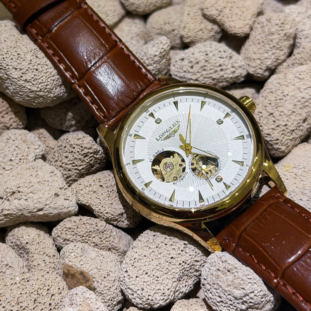 DALMONT Zenith gold automatic watch resting on pale stones, dial detail